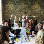 A group of participants voting with raised hands, expressing support for new ideas.